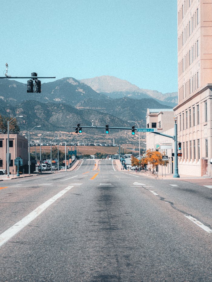 Quiet city street with traffic lights and mountain view.